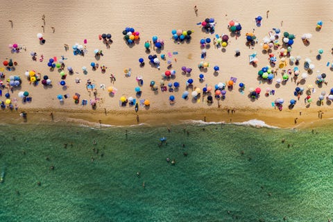 SARDINI ITALI  Het strand van de Cala Sinzias aan de zuidoostkust van Sardini is bezaaid met kleurrijke parasols Fotograaf Matthew Borowick die er familieleden bezocht vertelt dat de Middellandse Zee er z helder was dat je niet kon zeggen hoe diep het was