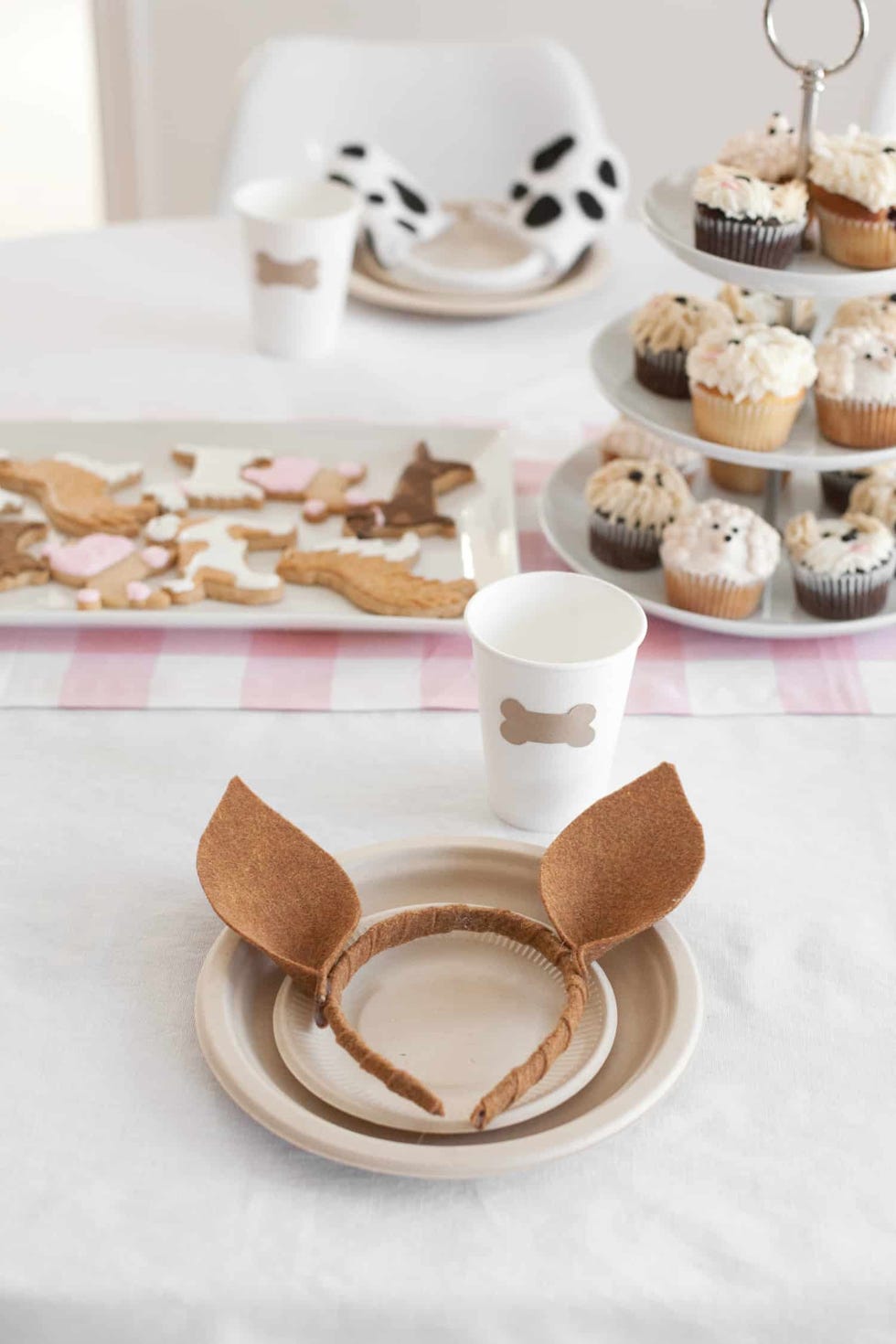 a puppy themed first birthday party includes dog ears and cookies shaped like dog biscuits