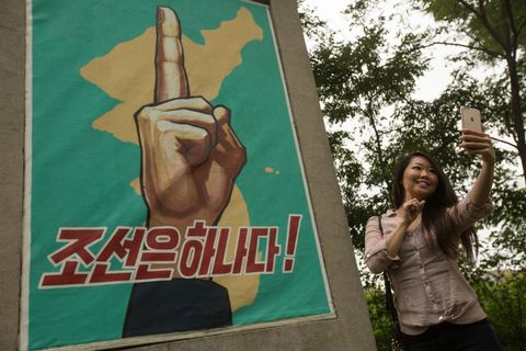 De Amerikaanse toeriste Amy Kang maakt een selfie bij een propagandamonument in Panmunjom in NoordKorea vlak bij de DMZ