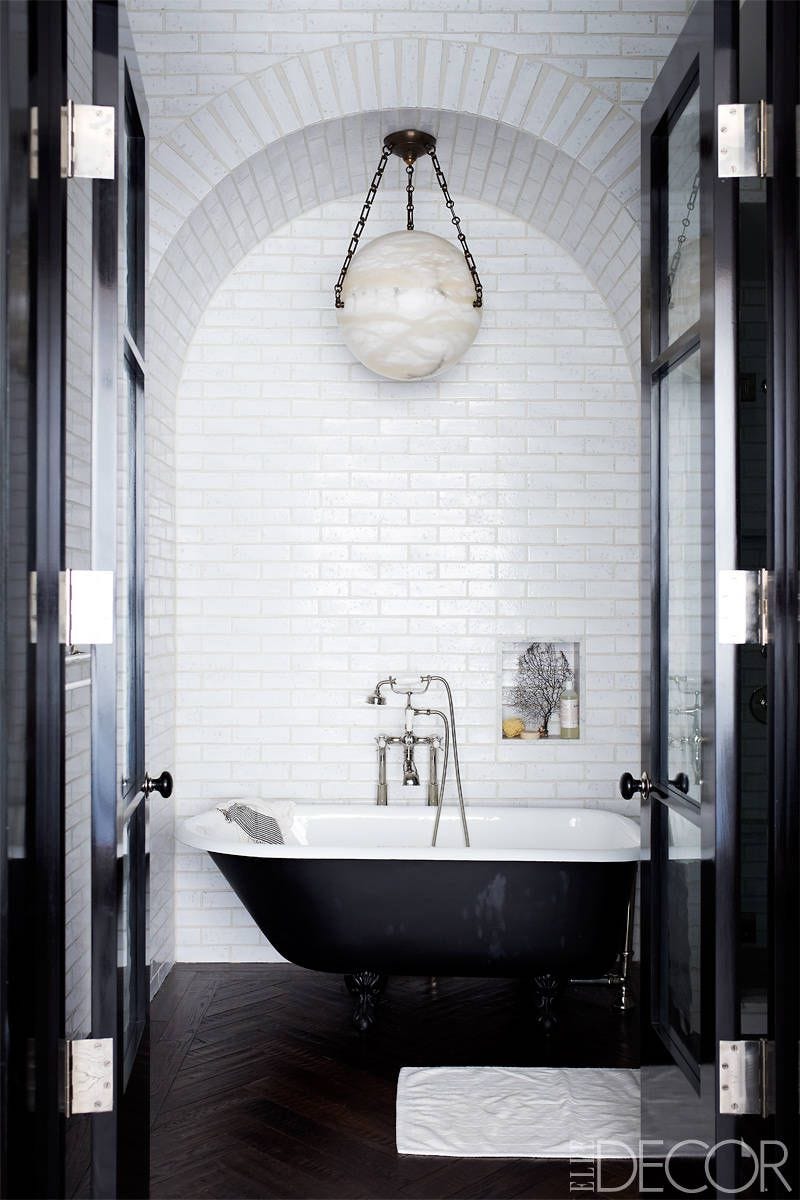 master bathroom with a small inset shower niche holding basics like a sponge, with a standalone tub underneath