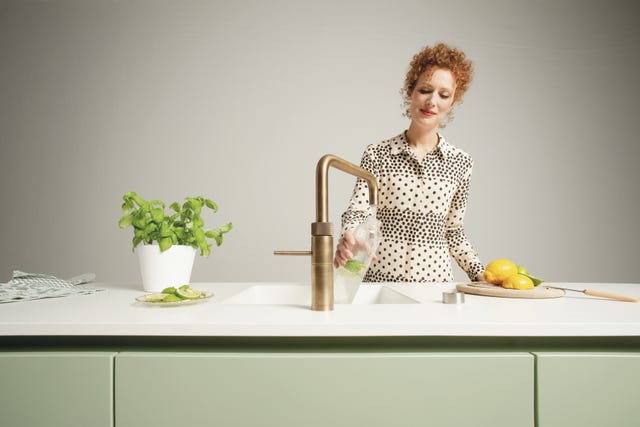 kitchen scene with a person pouring from a glass jug