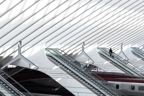 Een eenzame passagier neemt de roltrap omhoog in station LuikGuillemins in Belgi Met het koepelvormige dak verbond de Spaanse architect en ontwerperSantiago Calatravatwee wijken van de stad zowel fysiek als symbolisch met elkaar