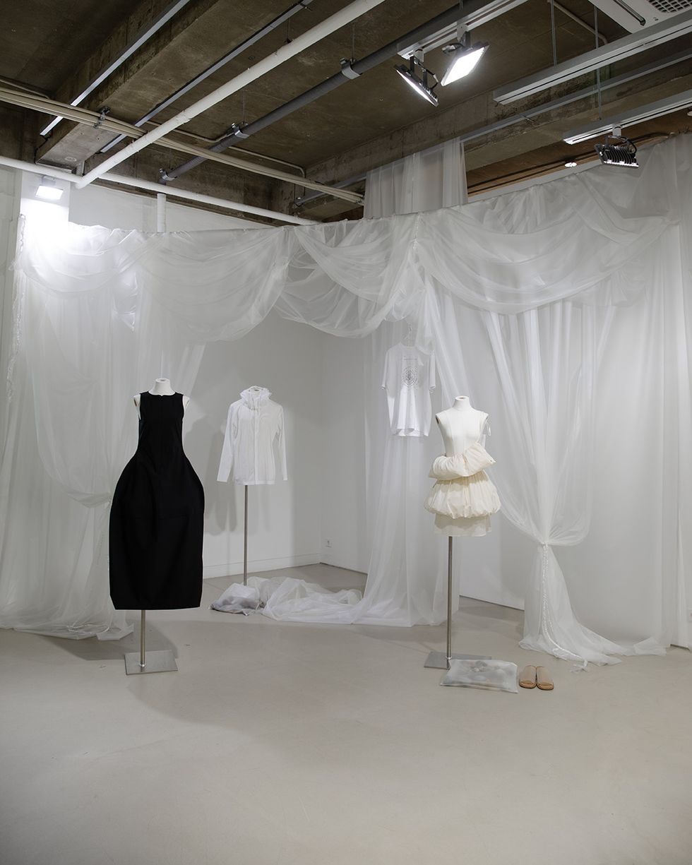 a room with white dresses and white curtains