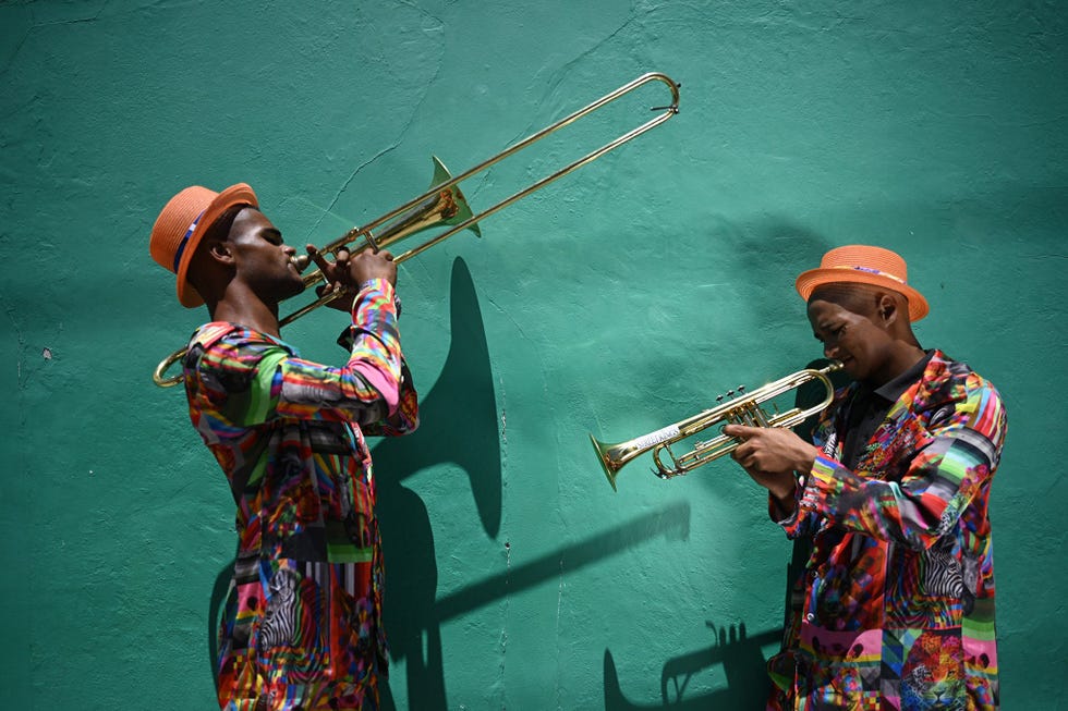KAAPSTAD ZUIDAFRIKA  In de wijk BoKaap in Kaapstad vormen scherpe schaduwen en een jadekleurige muur een fraaie achtergrond voor trombone en trompetspelers Rudi Jacobs en Abdul Baasit leden van de plaatselijke brassband The Street Kings