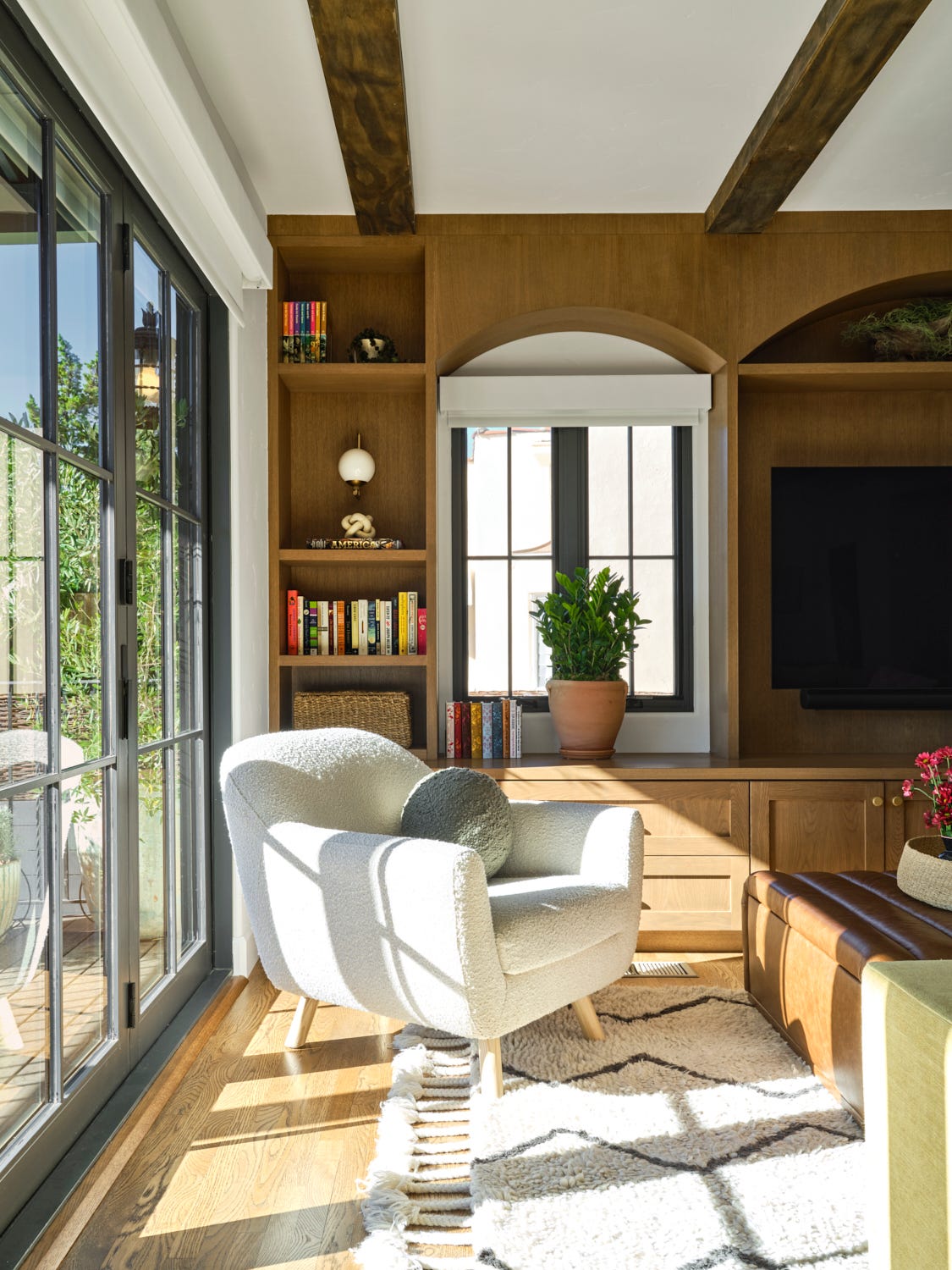 a bright living room features a textured white chair with rounded lines and a decorative pillow