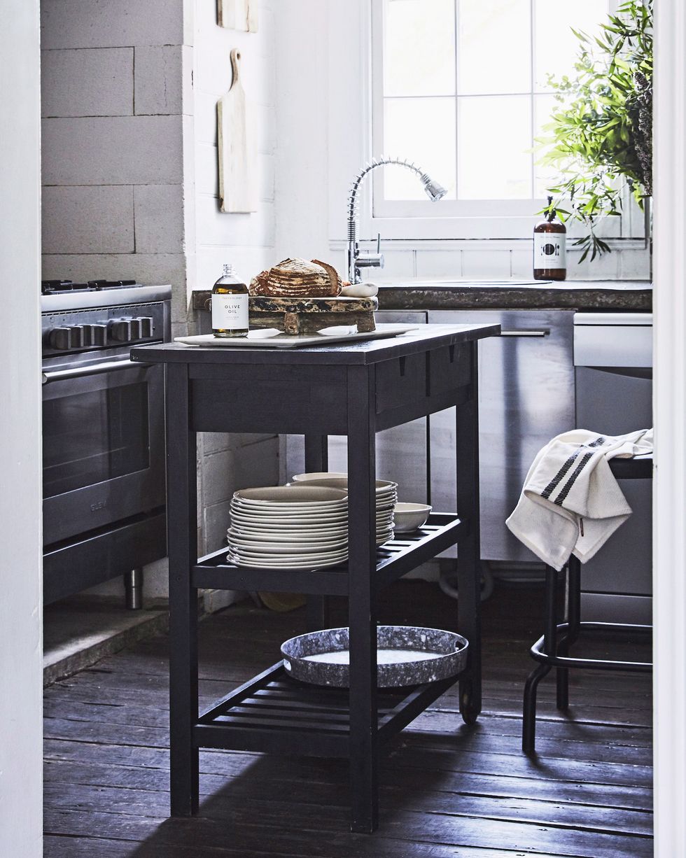 a rustic kitchen with black wooden kitchen island used to store crockery