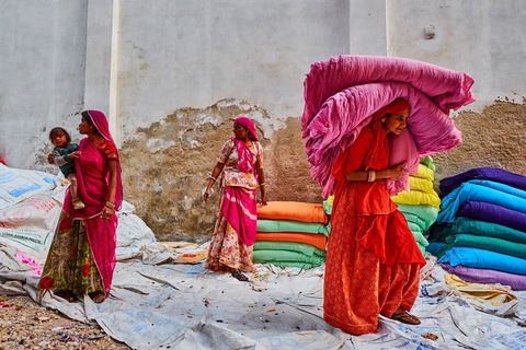 In een fabriek in Rajasthan vergaren vrouwen pas gedroogde saris Vr de introductie van synthetische verfstoffen in de negentiende eeuw werden saris geverfd met natuurlijke pigmenten als indigo en meekrap