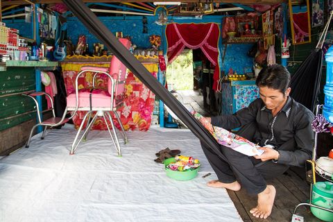 Kapper Trai wacht in zijn tijdelijke salon thuis op klanten Hij is een van de weinige kappers in het dorp