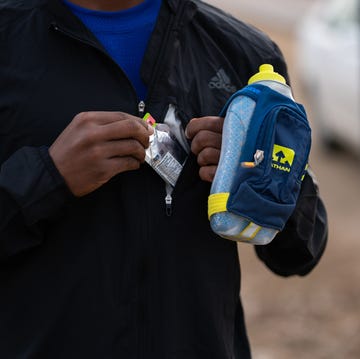 DMRWX runner preparing to consume a sports gel while holding a hydration pack