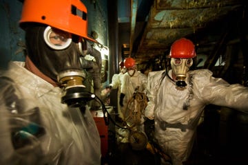 2005 arbeiders met plastic overalls en ademhalingsmaskers ter bescherming houden kort pauze terwijl ze gaten boren voor steunstangen in de wankele betonnen sarcofaag een constructie die na de explosie in de haast werd gebouwd om het radioactieve afval van reactor 4 te isoleren hun werk is gevaarlijk de straling is binnen zo hoog dat ze continu hun geigertellers in de gaten moeten houden ze mogen slechts een dienst van 15 minuten per dag draaien