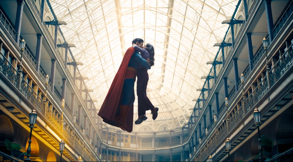 Superheroes and companions involved an intimate moment in a large atrium.