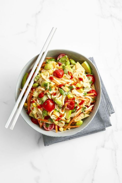 noodle salad with edamame, tomato, corn, shredded carrots in a white bowl