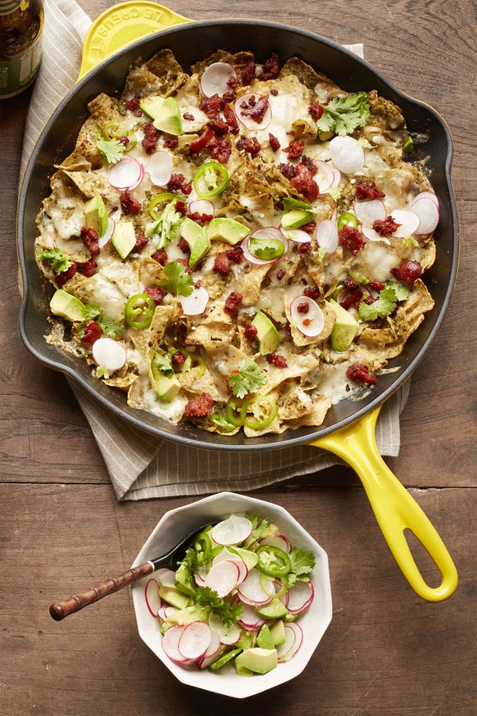 chorizo chilaquiles in black skillet on wood table