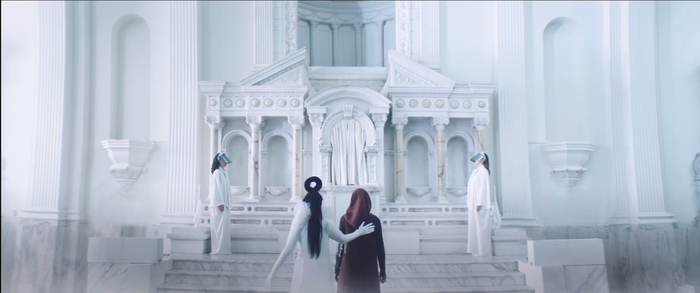 Cinematic scene featuring figures in a grand white hall.