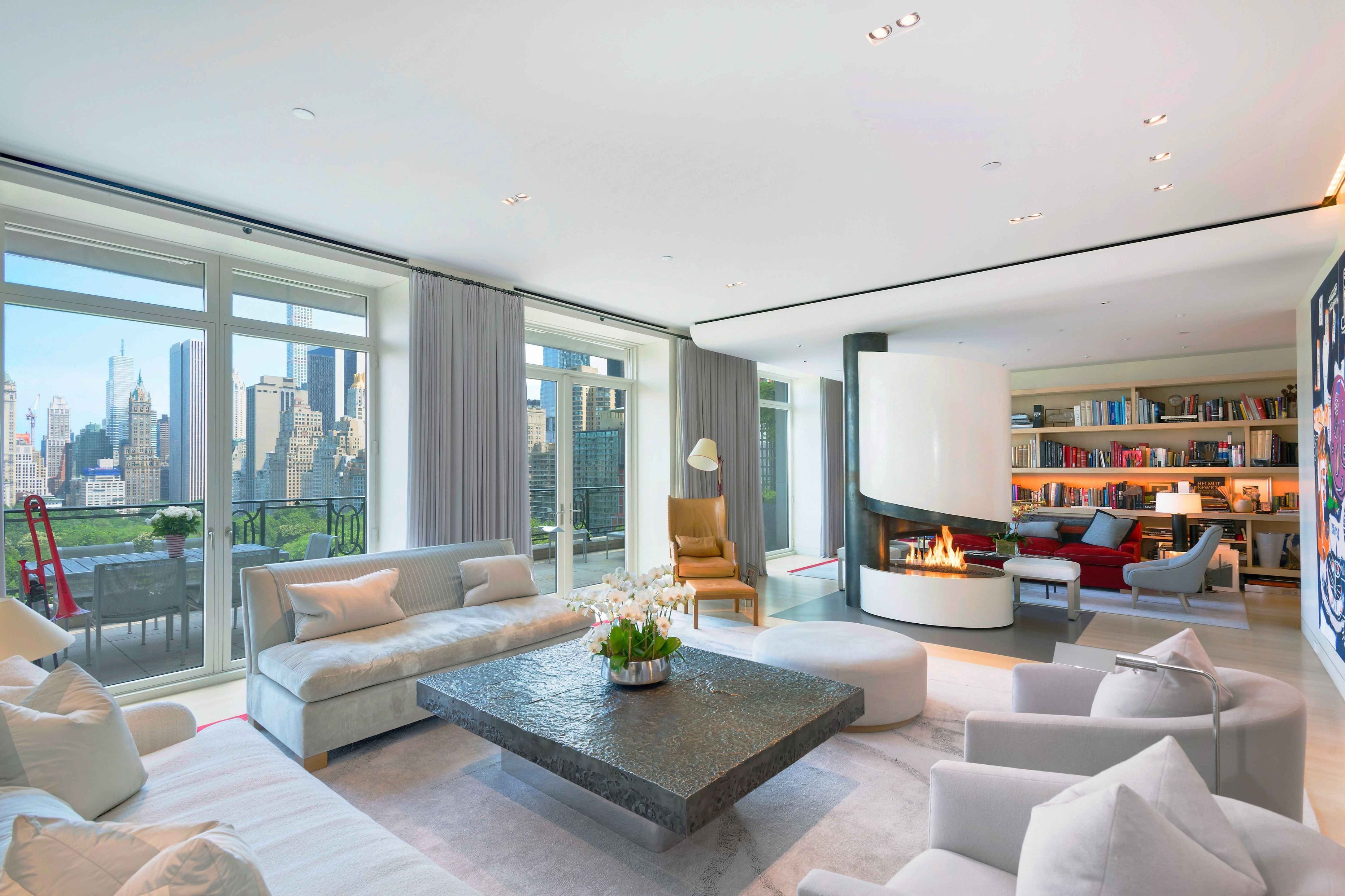 Sting and Trudie Styler's luxurious New York City apartment at 15 Central Park West, featuring skyline views, a fireplace, and modern decor.