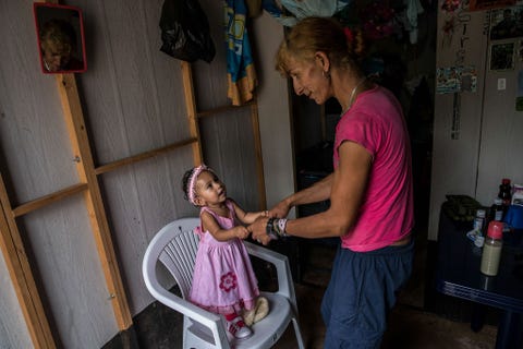 Esperanza speelt met haar dochtertje Desiree Het meisje heeft een nieuw jurkje aan een cadeautje voor haar eerste verjaardag