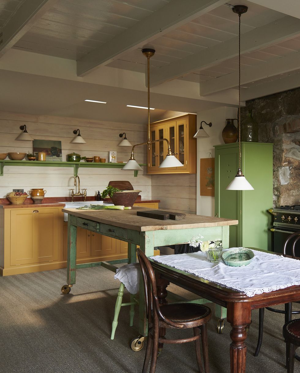 a yellow and green kitchen with a mix of built in and freestanding units