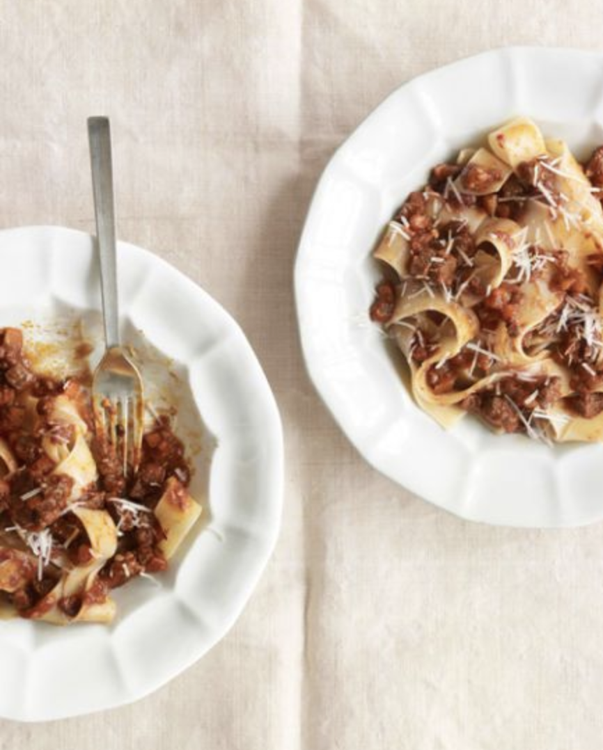 pappardelle pasta on white plates with meat sauce
