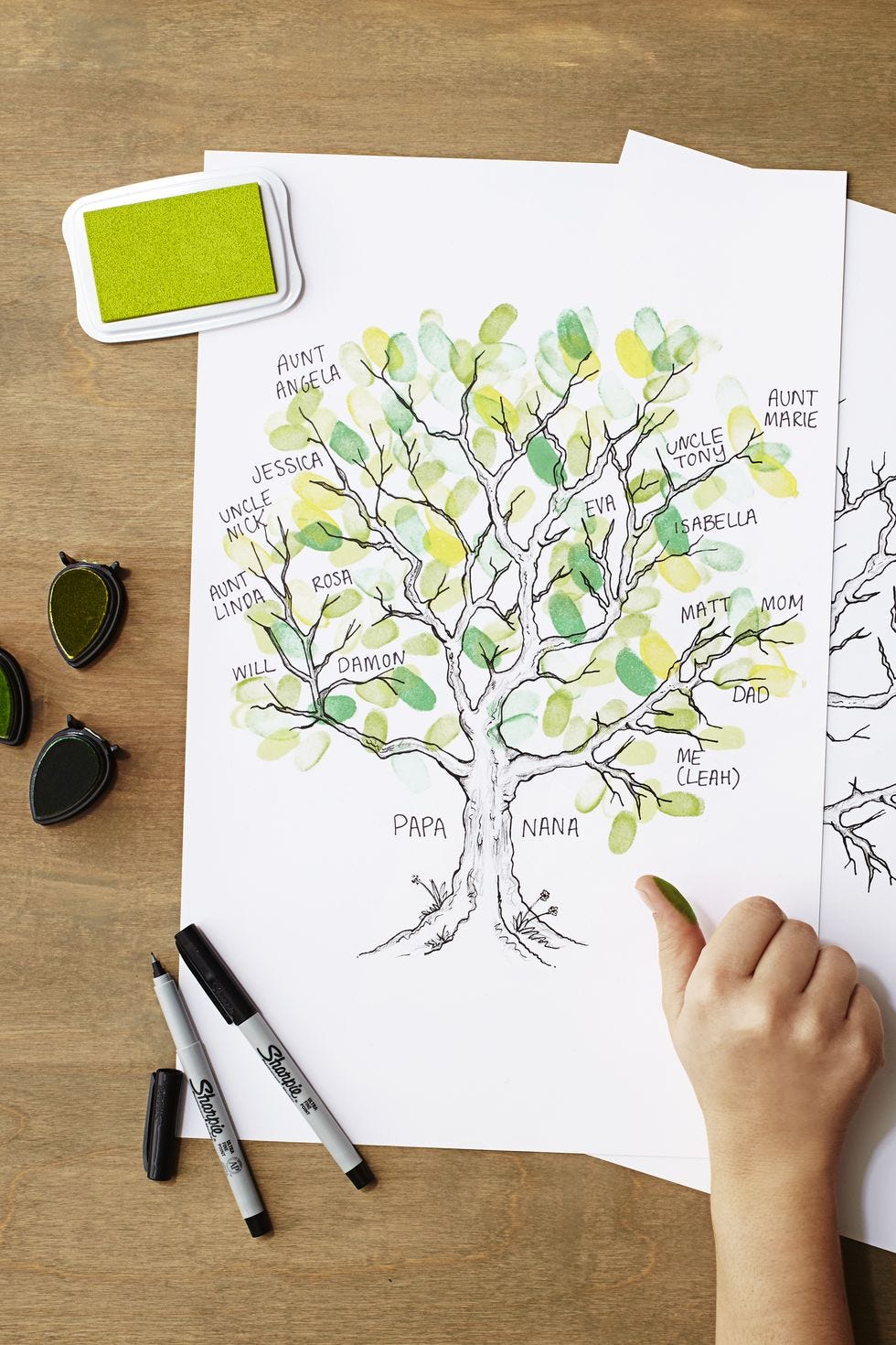 a drawing of a family tree on a piece of paper made out of green fingerprints