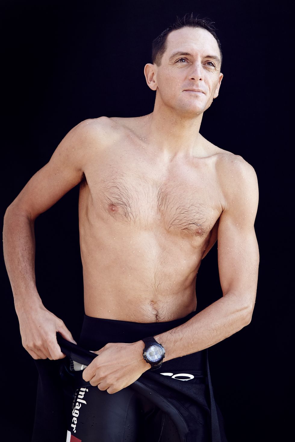 man wearing wet suit, folded down showing bare chest