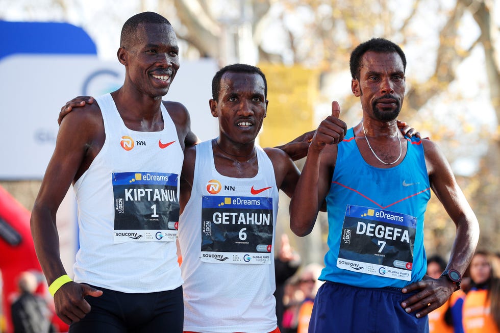 El atleta keniano Eric Kiptanui (i) junto al segundo clasificado, el etíope Adebe Degefa (d) y el tercero Betesda Getahun (c), en el podio tras su participación en la 29ª edición de la eDreams Medio Maratón de Barcelona.