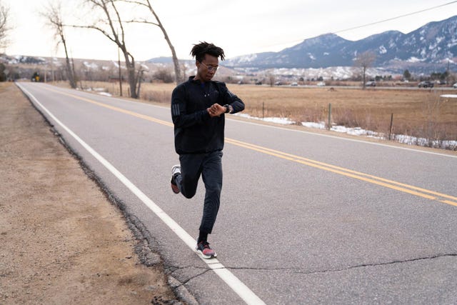a person jogging along a rural road with mountains in the background