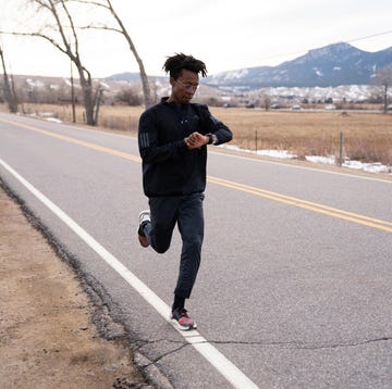 a person jogging along a rural road with mountains in the background a person jogging along a rural road with mountains in the background