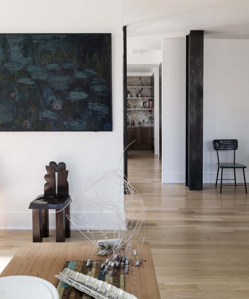 Modern living space featuring artwork, furniture, and a view into another room.