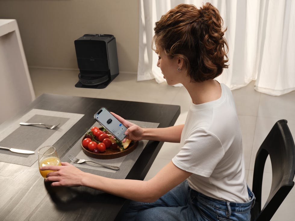 person using a smartphone at a dining table with food and drink