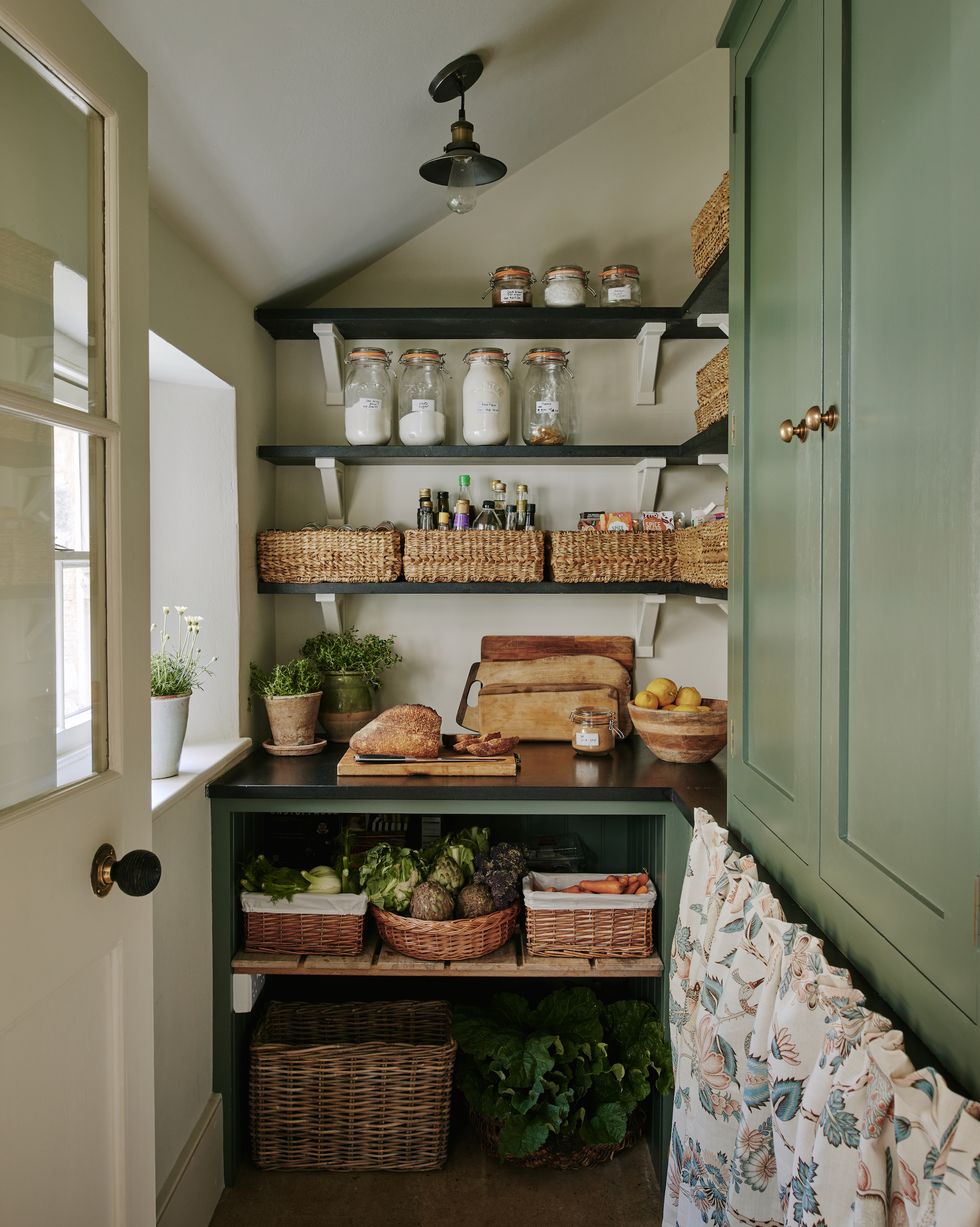 an organised kitchen pantry with baskets of produce and a worksurface
