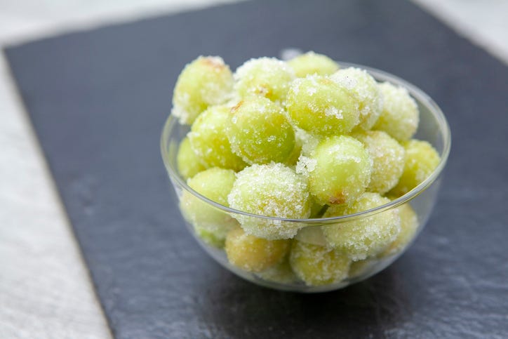 small glass bowl of green frozen grapes, a healthy sweet snack