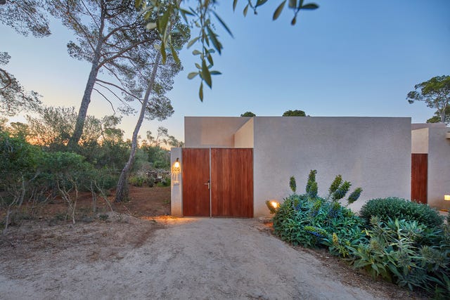 Modern building entrance surrounded by greenery.