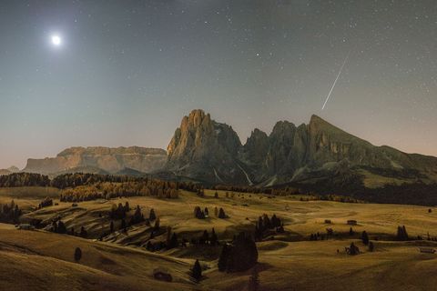 Op een vroege herfstochtend schiet een meteoor door de hemel boven de Dolomieten in het Italiaanse ZuidTirol