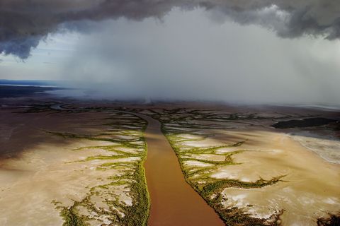 Laaghangende regenwolken pakken zich samen boven een rivier in WestAustrali