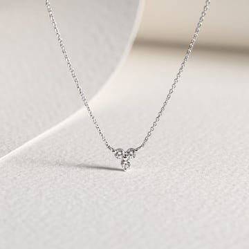 a silver chain on a white surface