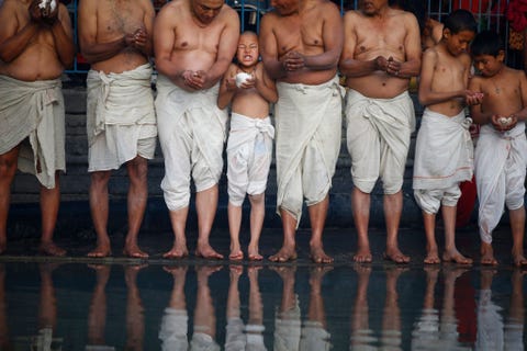 Een Hindoestaanse jongen uit Nepal vlak voordat hij zich in de rivier onderdompelt tijdens het festival Madhav Narayan in Bhaktapur