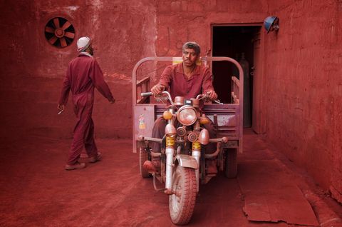 Een mijnwerker pauzeert in een okermijn op het Iranese eiland Hormuz Oker dat van nature roodbruin is wordt gebruikt in verf cosmetica en keramiek