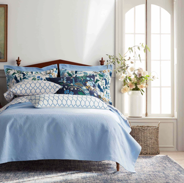 a bed with a blue and white comforter