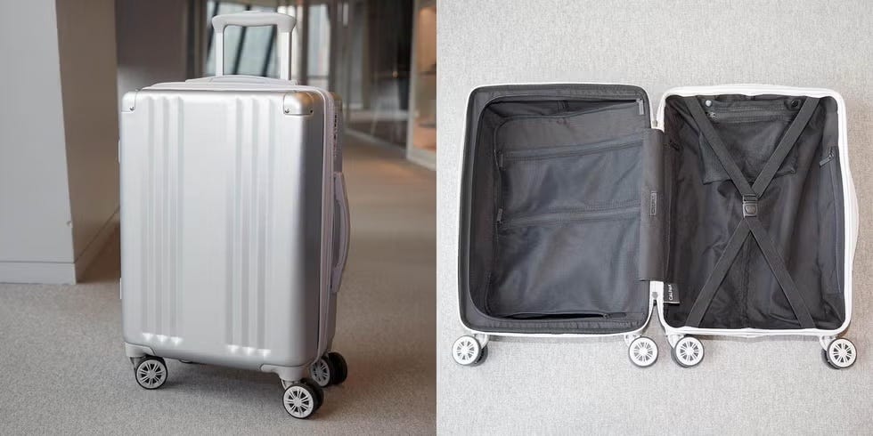 a calpak suitcase upright and lying open in a hallway