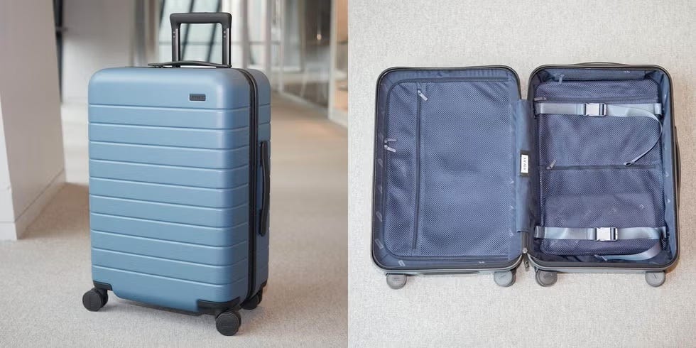 an away suitcase upright and lying open in a hallway