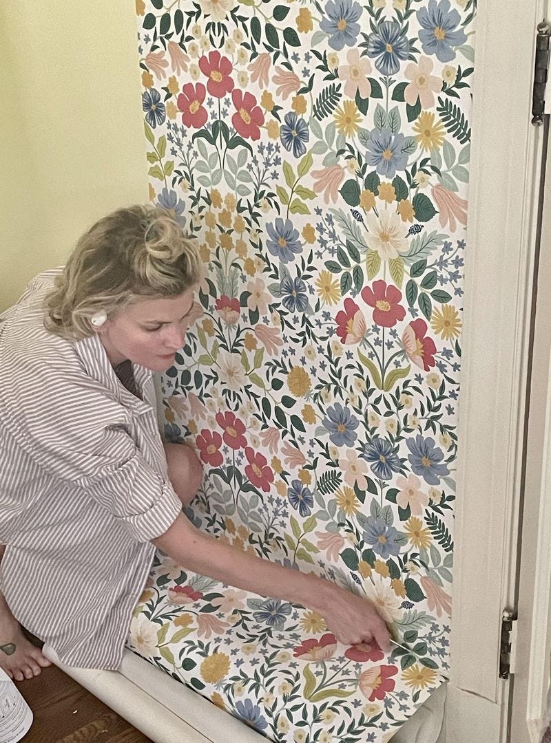 a person applying peel and stick wallpaper