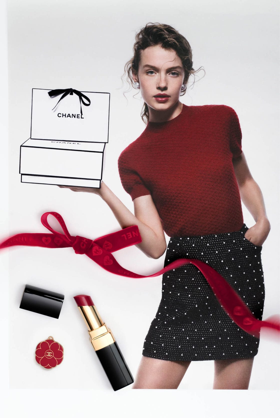 fashion model showcasing luxury items including a chanel gift box and cosmetics