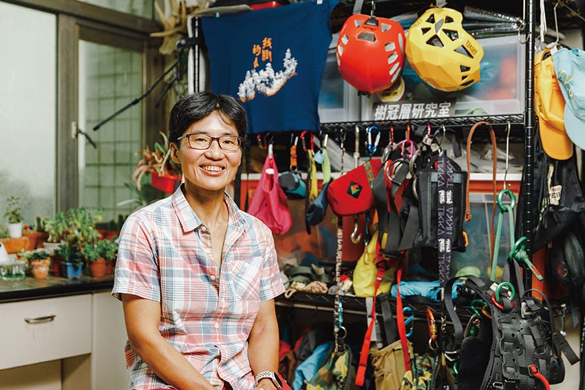 a person standing in front of a store with a variety of hats