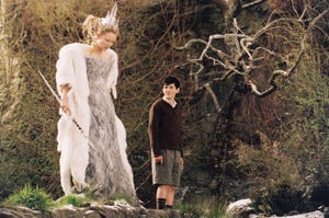 a man and woman standing in front of a rock wall