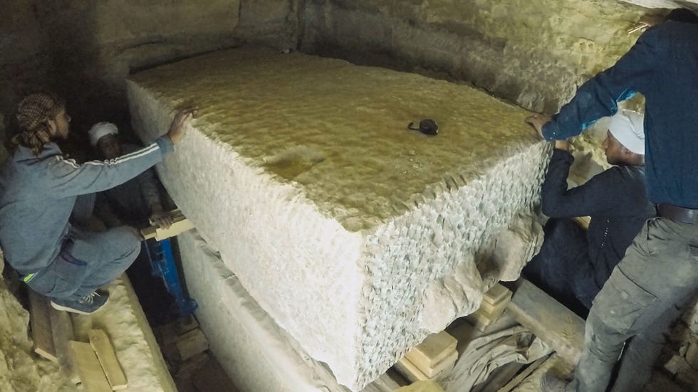 Met weinig bewegingsruimte in een claustrofobische grafkamer gebruiken arbeiders stalen kriks en slimme technieken om het bijna 5 ton zware deksel van een enorme sarcofaag op te tillen
