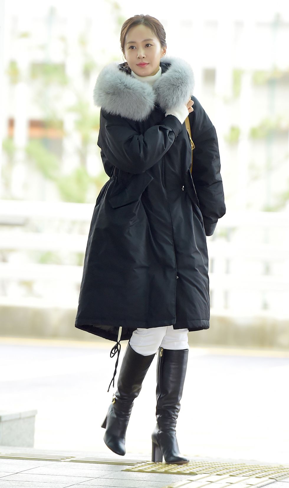 a woman wearing a coat and boots