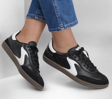black and white sneakers worn with blue jeans