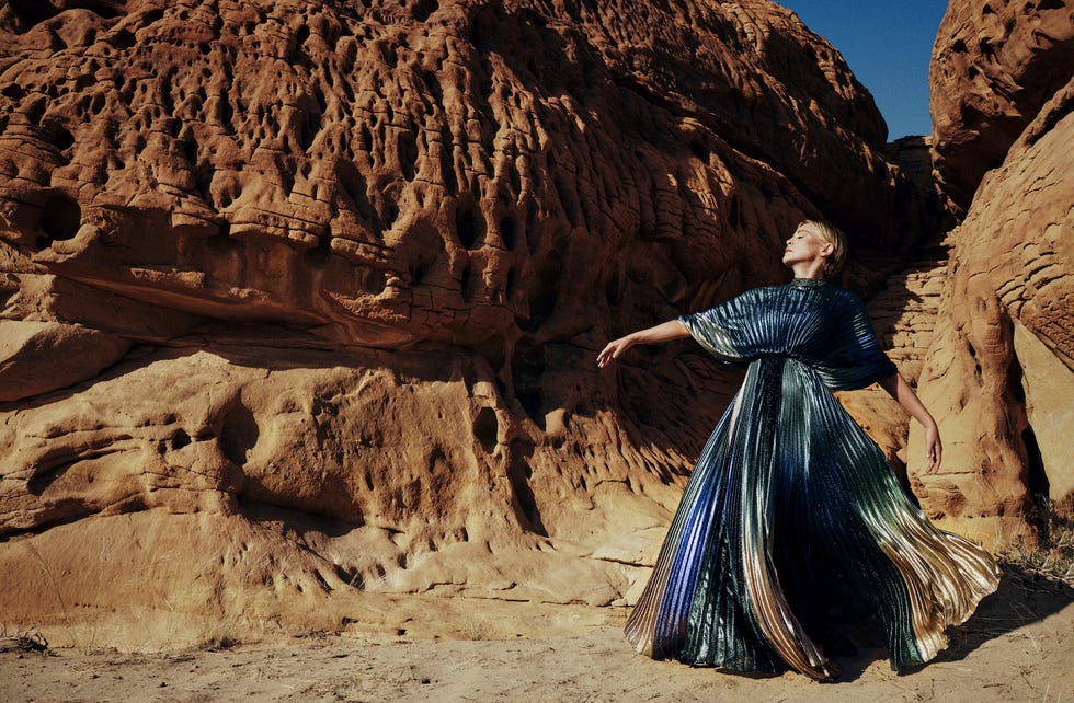 a person in a dress standing in a rocky canyon