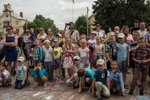 In Sjtsjastja in de oblast Loehansk luisteren bewoners naar een concert van de plaatselijke dansschool ter gelegenheid van Internationale Kinderdag