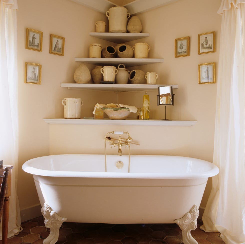 provence bathroom with ornate tub and corner shelves that feature a variety of pottery